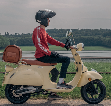 Jeune homme sur son scooter en campagne